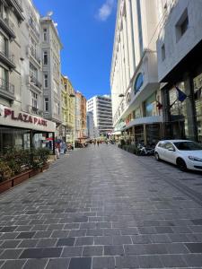 une rue pavée dans une ville avec de grands bâtiments dans l'établissement Taksim Beyoğlu Talimhane apart, à Istanbul
