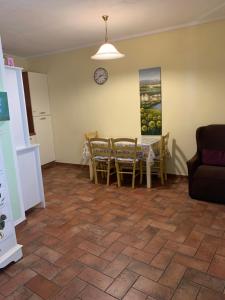 sala de estar con mesa, sillas y reloj en Dall’Artemio - appartamento a Sillico, en Sillico