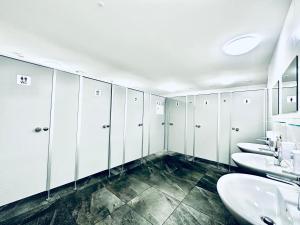 a bathroom with four sinks and white cabinets at Monteurzimmer - Worker's accommodation - ZIMMERzuVERMIETEN in Deitingen Industriestrasse in Deitingen +10 photos