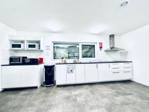 a large white kitchen with white cabinets and appliances at Monteurzimmer - Worker's accommodation - ZIMMERzuVERMIETEN in Deitingen Industriestrasse in Deitingen