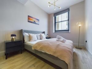 Schlafzimmer mit einem Bett und einem Fenster in der Unterkunft Luxury Stylish 2bedroom City Centre Apt in Manchester