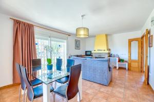 a dining room and kitchen with a glass table and chairs at Villa Casita - PlusHolidays in Calpe