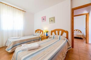 two beds in a room with a room with a table at Villa Casita - PlusHolidays in Calpe