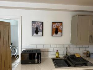 a kitchen with a sink and a microwave at Calverley House Apartments in Bishops Stortford