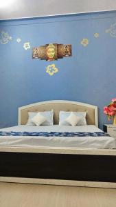 1 dormitorio con 1 cama con pared azul en VIP Guest House Bodhgaya, en Gaya