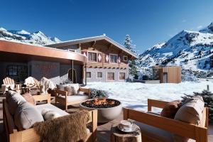 a ski lodge with snow covered mountains in the background at Kesselspitze Valamar Collection Hotel Superior in Obertauern