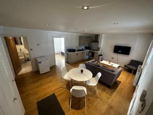 a living room with a table and a couch at Calverley House Apartments in Bishops Stortford