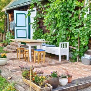 un patio con mesa, sillas y banco en Magiczne Podlasie 