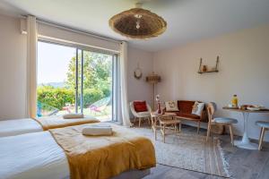 a bedroom with a bed and a large window at Le Nichoir de la Colline - Parking & Wifi in Obernai