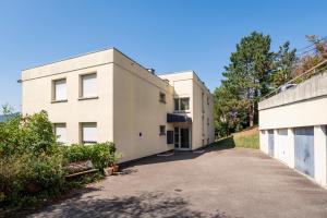 a white building with a driveway in front of it at Le Nichoir de la Colline - Parking & Wifi in Obernai