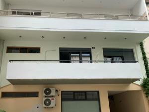 a white building with a balcony and speakers at Just like Home in Sitia
