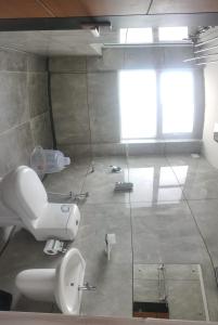 baño con aseo y ventana en Burj Munnar en Anachal