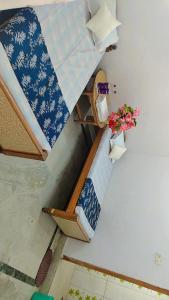 VIP Guest House Bodhgaya في جايا: غرفة بسريرين بطابقين مع ورود على الحائط