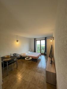 sypialnia z łóżkiem i stołem w obiekcie Appartement T1 w mieście LʼÎle-Rousse