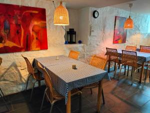 um restaurante com mesas e cadeiras e pinturas na parede em Sjøgløtt Gjestgiveri em Kristiansand