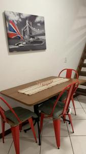 a wooden table with two chairs and a picture on the wall at Flat lindo paraty in Paraty +12 photos