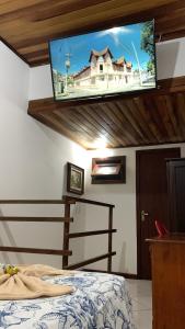 a bedroom with a bed with a tv on the ceiling at Flat lindo paraty in Paraty