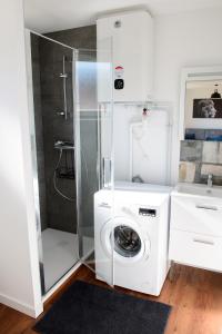 a bathroom with a washing machine and a shower at Le Forez 