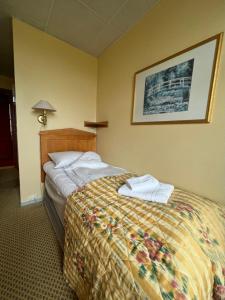 a hotel room with a bed with towels on it at Øvre Sem Gård in Asker