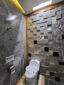 a bathroom with a toilet and a tile wall at Blue Palm Kata Resort in Kata Beach