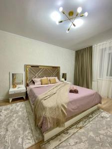 a bedroom with a large bed and a ceiling fan at 1-комнатная квартира в районе Космос in Aktobe