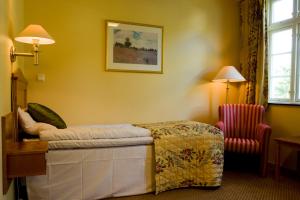 a hotel room with a bed and a chair at Øvre Sem Gård in Asker