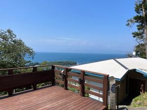 eine Holzterrasse mit Meerblick in der Unterkunft ゲストハウスジャパン西伊豆/The Guest House Japan Nishi-Izu in Toda