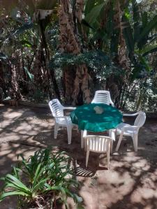 Casa condomínio paz في بتروبوليس: طاولة وكرسيين وطاولة خضراء