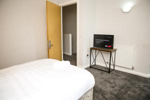 a bedroom with a bed and a television on a table at Crystal Home in Manchester