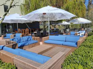 a seating area with blue couches and umbrellas at Wildeshauser Hof in Wildeshausen