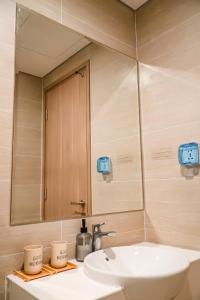 La salle de bains est pourvue d'un lavabo et d'un miroir. dans l'établissement Vinhomes Grand Park - COZIroom, à Gò Công