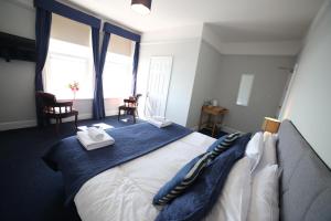 a bedroom with a large bed with towels on it at Royal Temple Yacht Club in Ramsgate