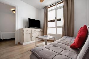 - un salon avec un canapé et une télévision dans l'établissement Apartamento Playa Morro Jable 1a, à Morro del Jable