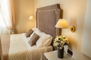 a bedroom with a bed and a table with a vase of flowers at Hotel Rosa Dei Venti in Lerici