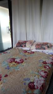 a bed with flowers on it in a bedroom at Caiowa Floripa guesthouse in Florianópolis