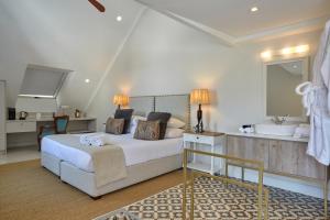 a bedroom with a bed and a sink and a tub at Chapter House Boutique Hotel by The Living Journey Collection in Franschhoek