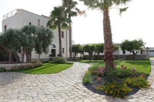 a courtyard with a palm tree and a building at Casal Sikelio in Cassibile