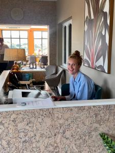 une femme assise à un bureau dans un bureau dans l'établissement The Spa Hotel, à Saltburn-by-the-Sea