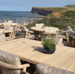 a group of tables and chairs with the ocean in the background at The Spa Hotel in Saltburn-by-the-Sea