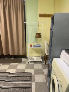 a laundry room with a washing machine and a tiled floor at Vahe's family Guest House front in Yerevan