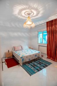 - une chambre avec un lit et un lustre dans l'établissement sejour chez Marwa, à Sidi Bou Saïd