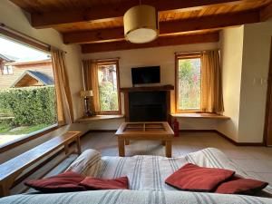 um quarto com uma cama, uma lareira e uma televisão em Casita Roca em San Martín de los Andes