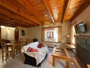 uma sala de estar com um sofá e uma mesa em Casita Roca em San Martín de los Andes