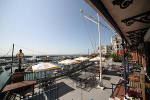a balcony with tables and umbrellas and a harbor at Royal Temple Yacht Club in Ramsgate