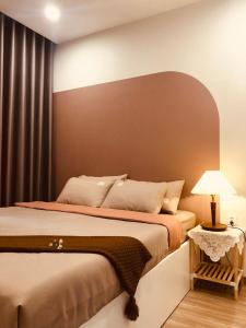 - une chambre avec un lit et une table avec une lampe dans l'établissement Vinhomes Grand Park - COZIroom, à Gò Công
