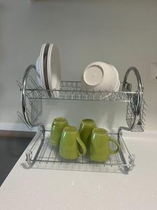 a rack with four green mugs and a plate at Muji Studio USJ in Subang Jaya