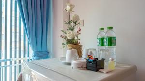 un tavolo con bottiglie d'acqua e fiori di Nice to meat you Rooms a Patong Beach