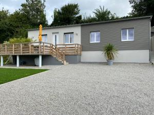 a house with a porch and a wooden deck at L’Albâtre - Maison située à quelques pas de la mer in Saint-Aubin-sur-Scie