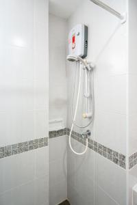 a shower in a bathroom with white tiles at Nice to meat you Rooms in Patong Beach