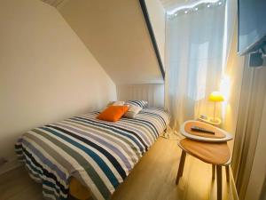 Dormitorio pequeño con cama y mesa en Chez Zivou au pied de la plage, en Mers-les-Bains